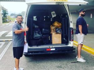 Professional driver loading luggage into a private shuttle van at a Costa Rica airport