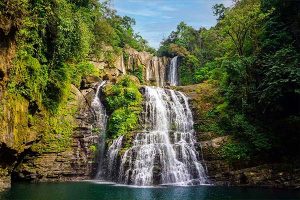 Scenic view Nauyaca Waterfalls cascading into a clear rainforest pool in Costa Rica, tourists can get there with our Costa Rica private transfers