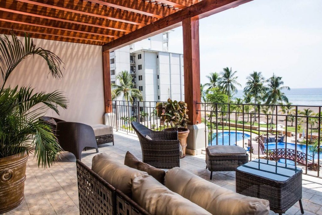 Balcony view at Croc’s Resort & Casino in Jaco, Costa Rica overlooking the pool area, palm trees, and Pacific Ocean