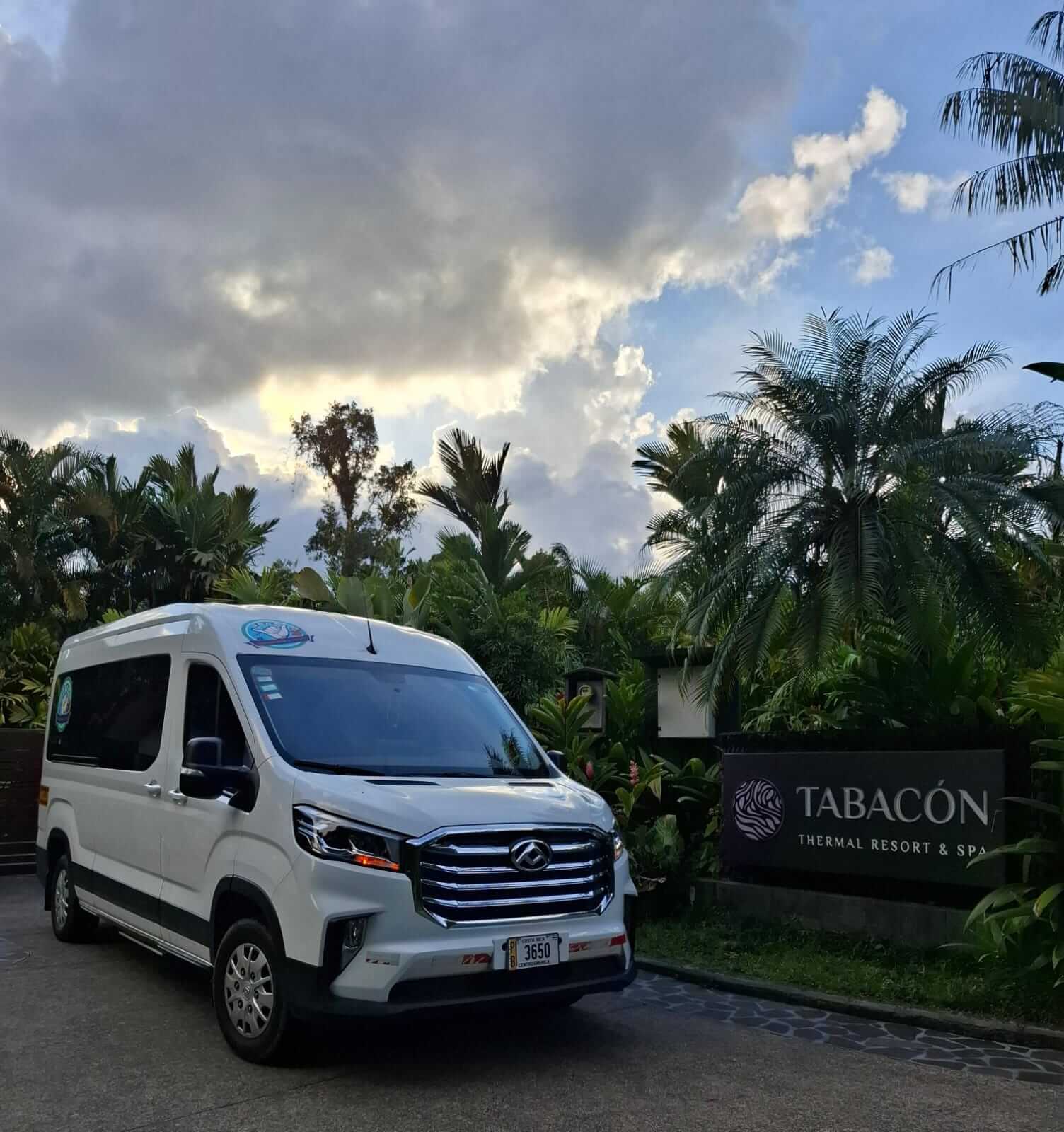 White private shuttle van parked at Tabacón Hot Springs entrance — private transportation in Costa Rica for travelers